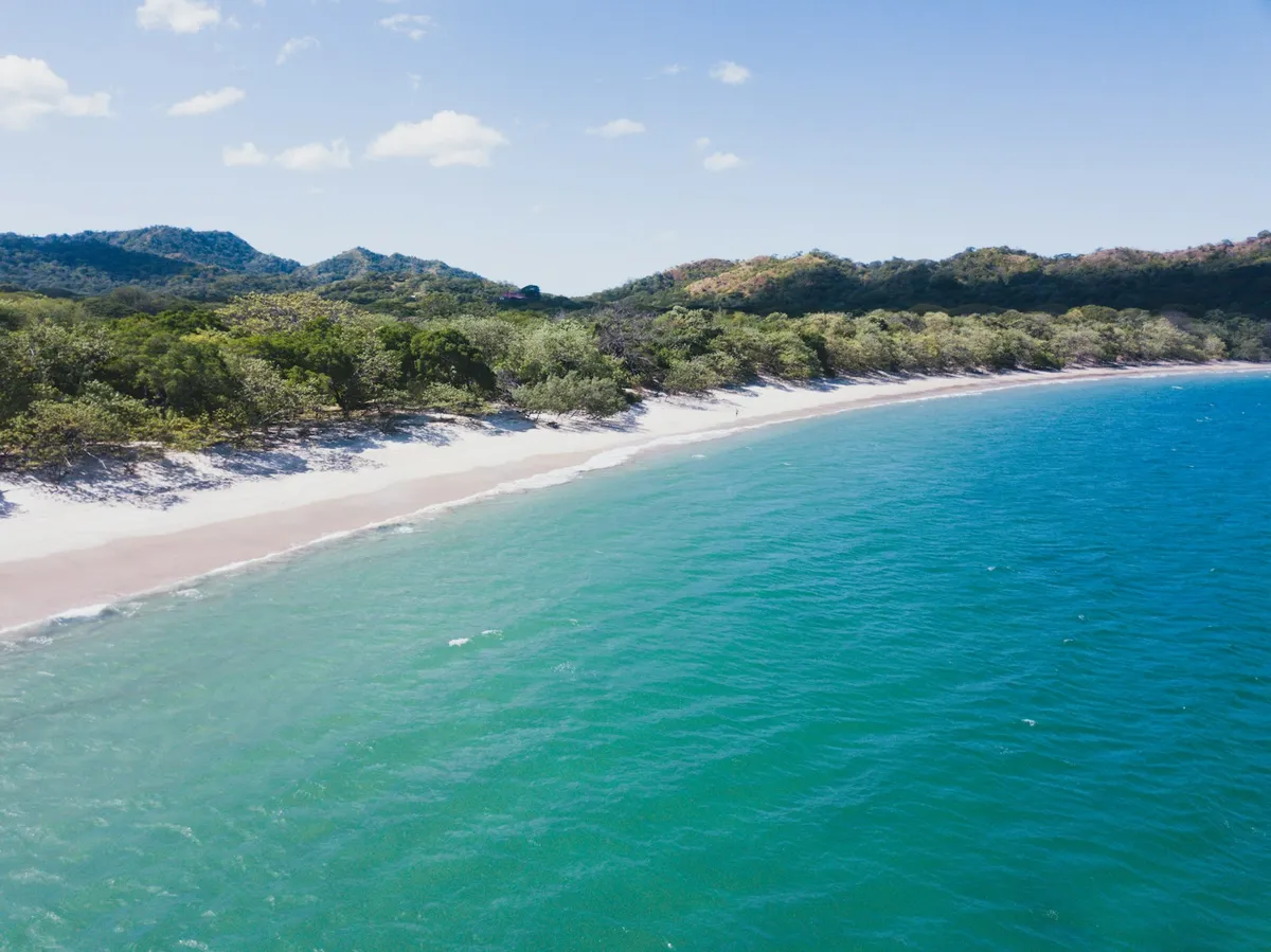 Calm, clear turquoise water on a white-sand Guanacaste beach in Costa Rica