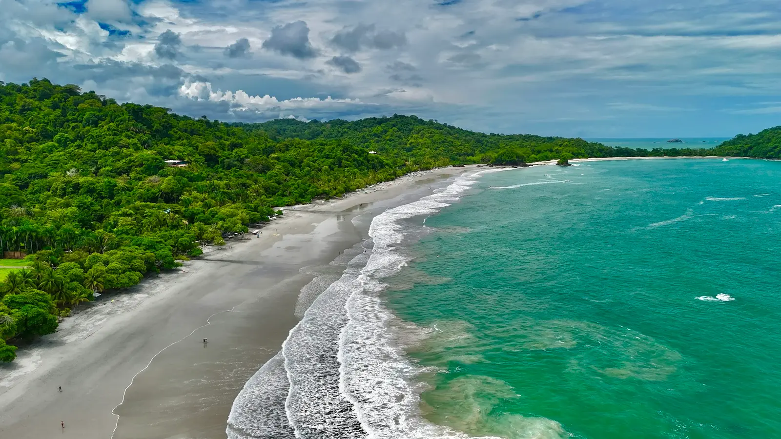 Sandy beach where dense rainforest meets the ocean at Manuel Antonio, Costa Rica